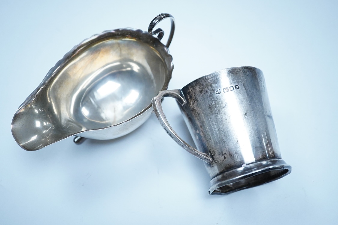 A George V silver sauceboat, by William Neale Ltd, Birmingham, 1925, length 14.6cm, together with a 1950's small silver mug, 6.6oz.